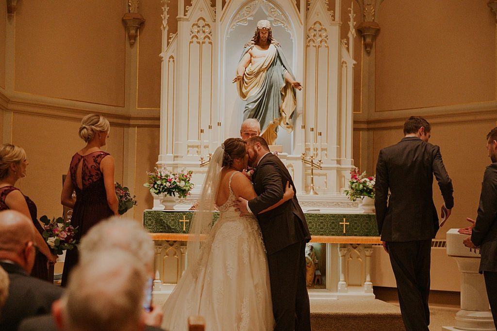Bride and groom kiss at altar in Appleton WI
