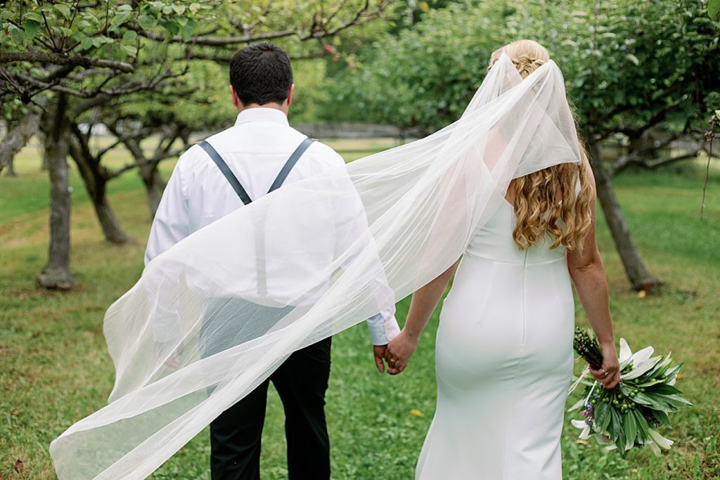 bride and groom walk in backyard